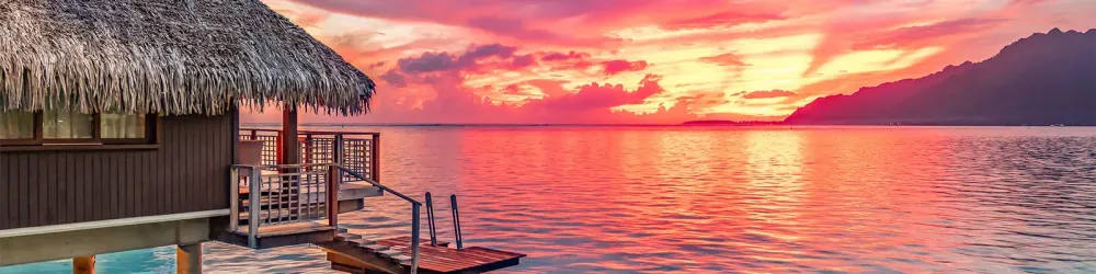 View of overwater bungalow at sunset